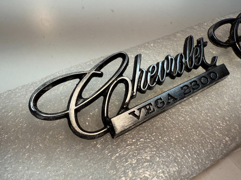 OEM 1971-75 Chevrolet Vega 2300 PAIR Emblem Nameplate Badge 9870383 B32-63