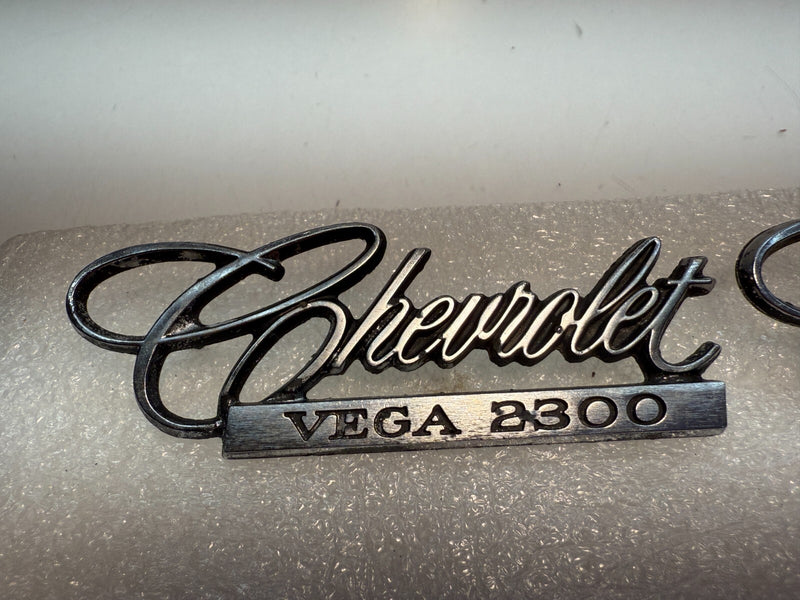 OEM 1971-75 Chevrolet Vega 2300 PAIR Emblem Nameplate Badge 9870383 B32-63